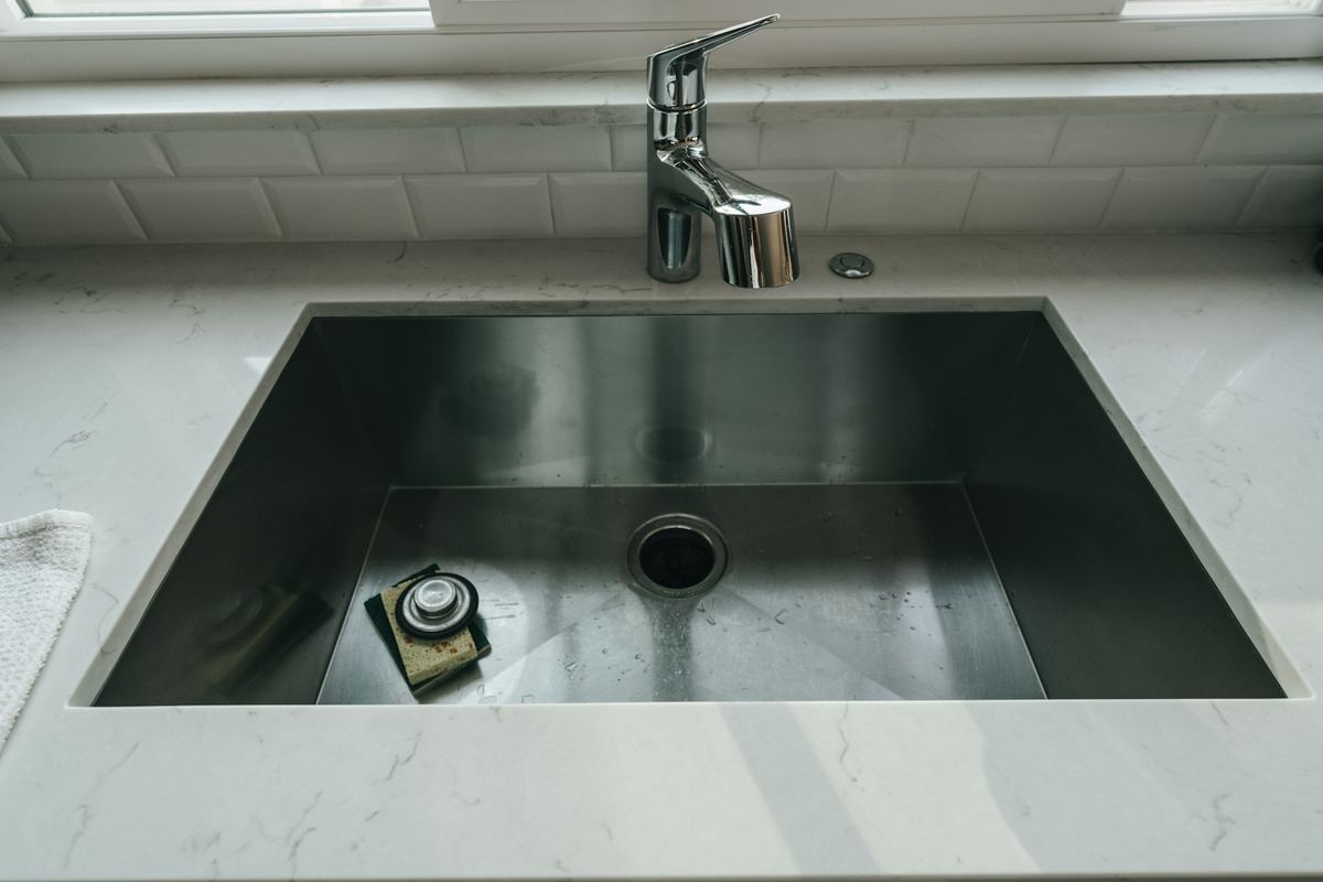 A kitchen sink running clear after a clog was cleared